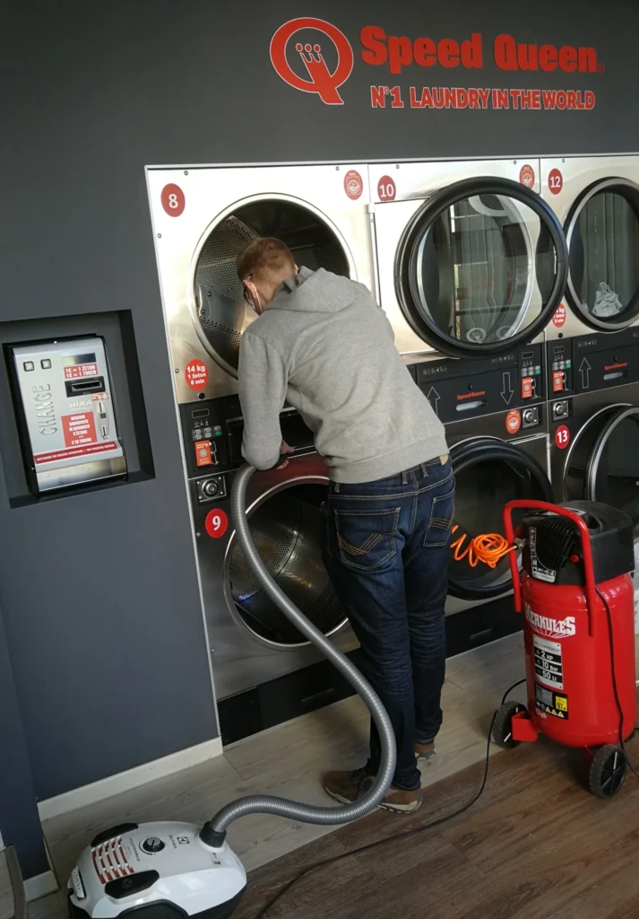 A photo of me cleaning my dryers in the laundromat.
